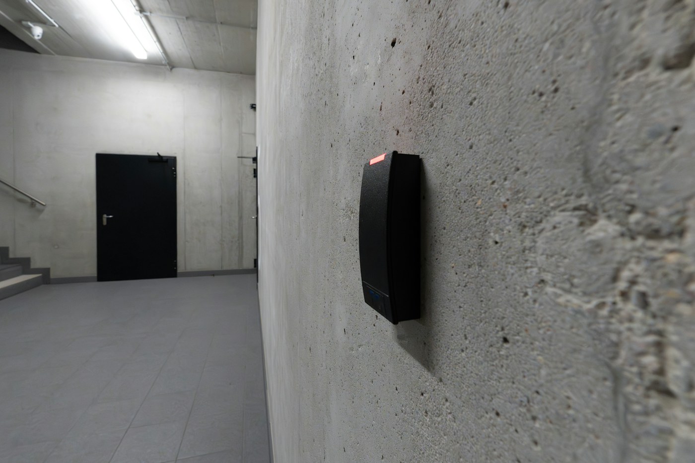 Real photograph of an electronic access-card reader mounted beside a commercial entry, illustrating equipment assessment before modernization