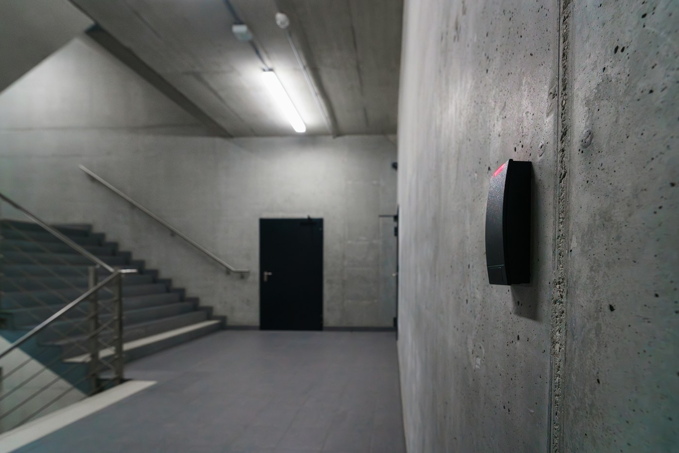 Real photograph of a commercial electronic access control card reader at a building entrance